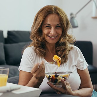 Smiling lady eats fruit