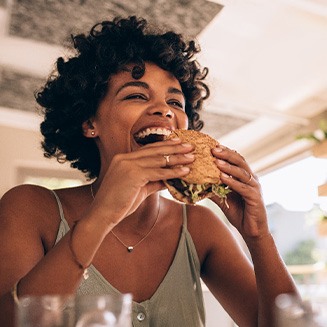 Woman smiling while eating lunch at restaurant