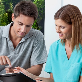 A young man paying for his dental care