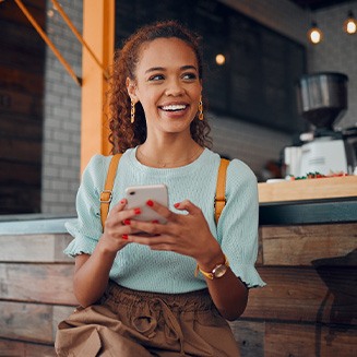 Smiling woman sitting on barstool at restaurant