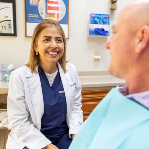 Doctor Zaharie smiling at a man in the dental chair