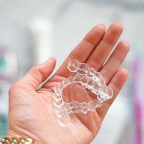 Hand holding two clear aligners