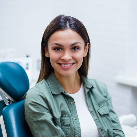 Woman smiling in dental chair during preventive dentistry checkup