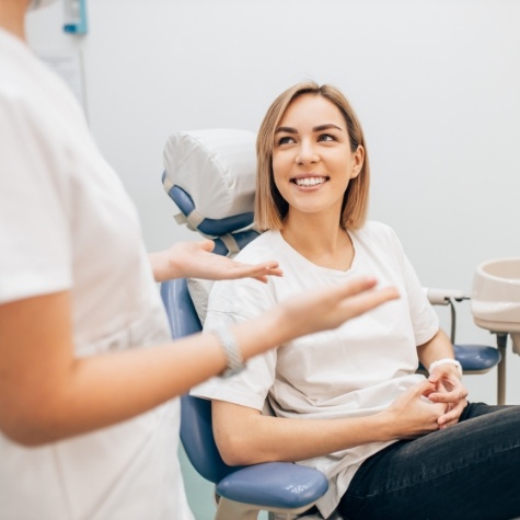Woman in dental chair smiling at her dentist in Fulshear